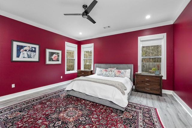 bedroom with ceiling fan, light hardwood / wood-style floors, and ornamental molding