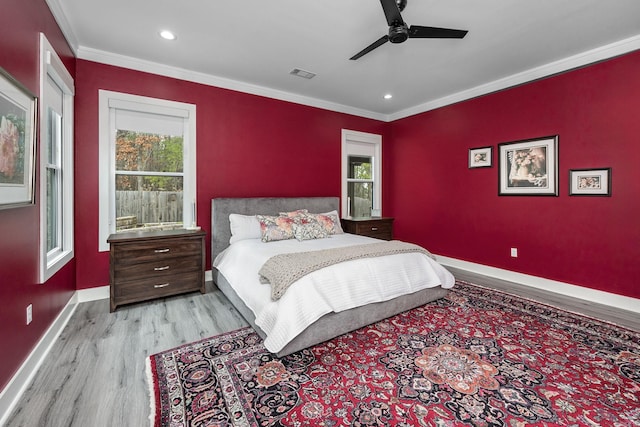 bedroom with light wood-type flooring, ceiling fan, and crown molding