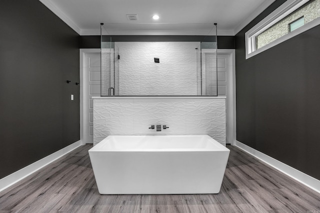 bathroom with hardwood / wood-style floors, ornamental molding, and shower with separate bathtub