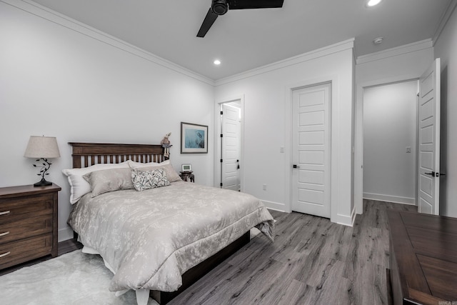 bedroom featuring light hardwood / wood-style flooring, ceiling fan, and crown molding