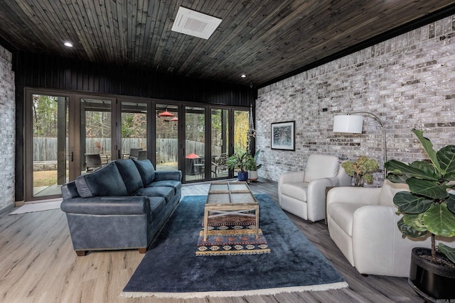 living room featuring wood-type flooring and brick wall