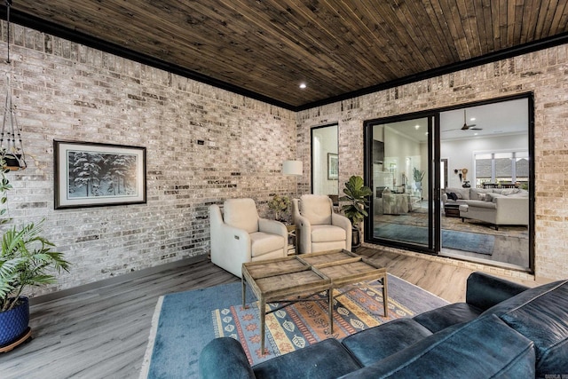 living room with hardwood / wood-style floors, ceiling fan, wood ceiling, and brick wall