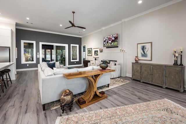 living room with light wood-type flooring, ceiling fan, and crown molding