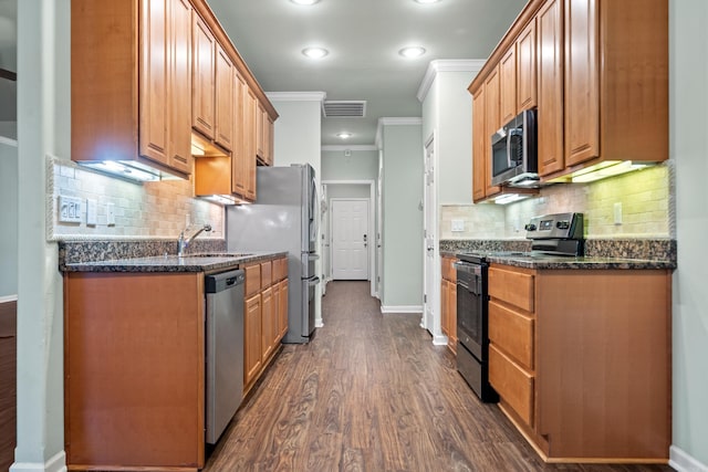 kitchen with sink, dark wood-type flooring, tasteful backsplash, appliances with stainless steel finishes, and ornamental molding