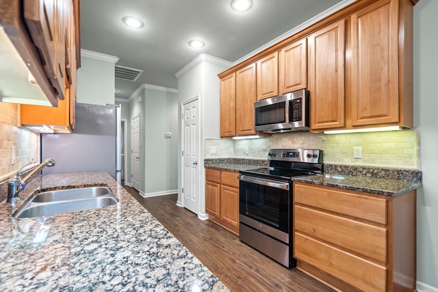 kitchen with sink, dark wood-type flooring, crown molding, decorative backsplash, and appliances with stainless steel finishes