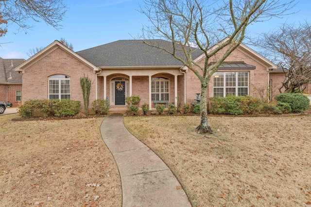 ranch-style house with covered porch and a front lawn