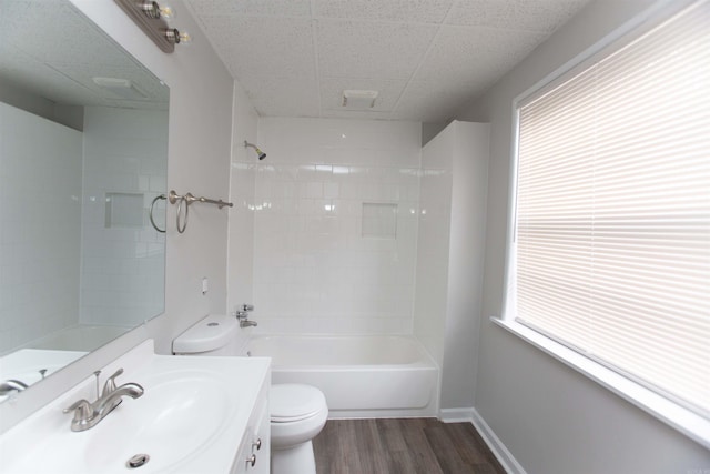 full bathroom featuring hardwood / wood-style floors, vanity, toilet, and tiled shower / bath