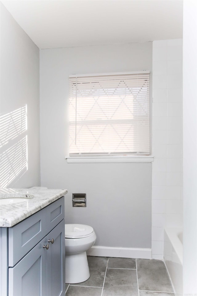 bathroom with toilet, vanity, and tile patterned floors