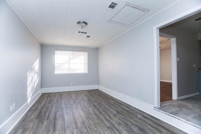 spare room with crown molding and dark wood-type flooring