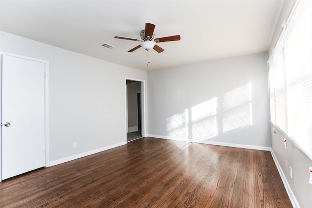 spare room with dark hardwood / wood-style floors and ceiling fan