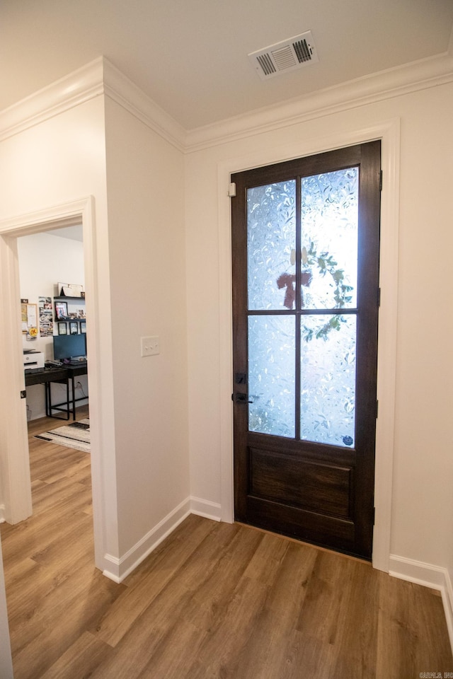 entrance foyer with hardwood / wood-style floors, french doors, and ornamental molding