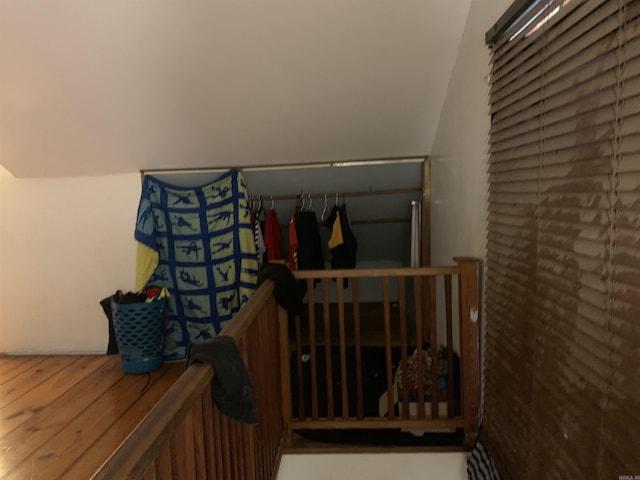 stairs featuring wood-type flooring and lofted ceiling