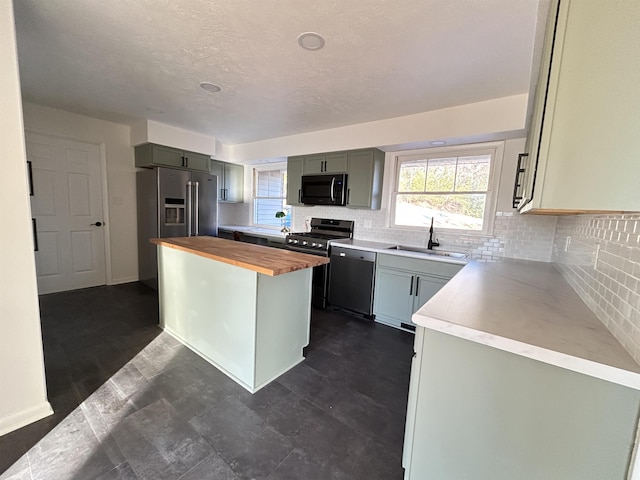 kitchen featuring a center island, backsplash, wooden counters, sink, and stainless steel appliances