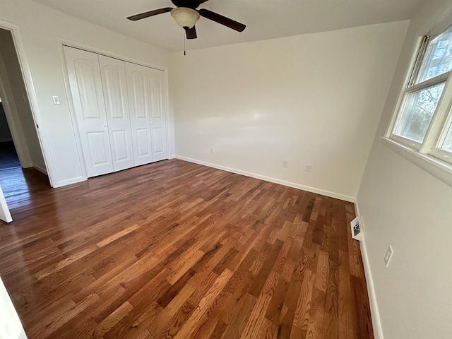 unfurnished bedroom featuring a closet, ceiling fan, and dark wood-type flooring