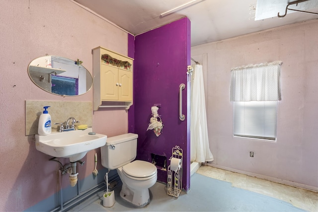 bathroom featuring a shower with curtain, toilet, and sink