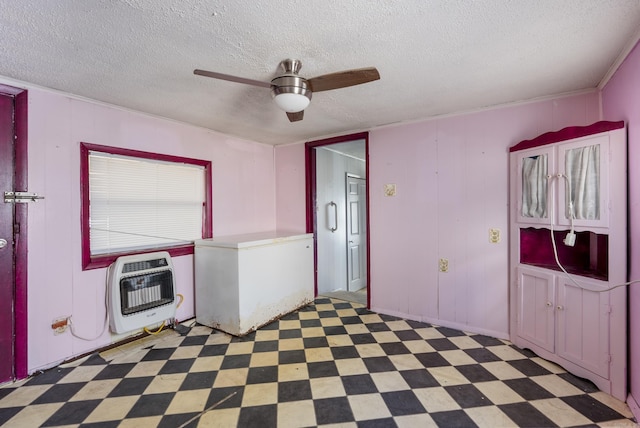 laundry area with a textured ceiling, heating unit, and ceiling fan