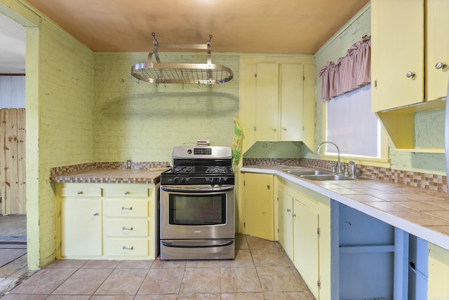 kitchen featuring light tile patterned floors, sink, and gas range