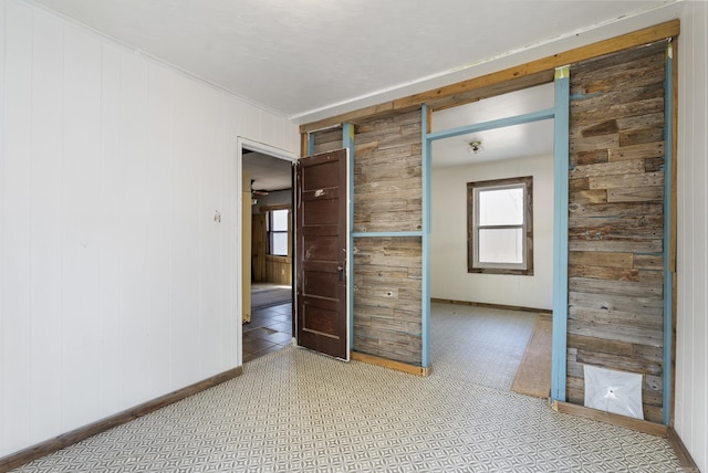 unfurnished room featuring wood walls