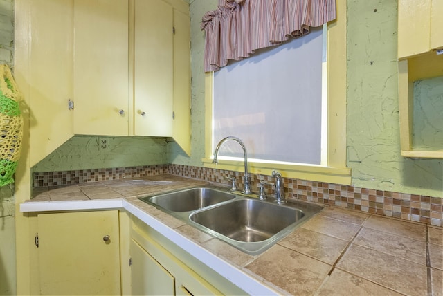 kitchen featuring cream cabinets, tile counters, and sink