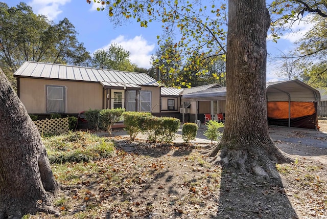 back of house featuring a carport