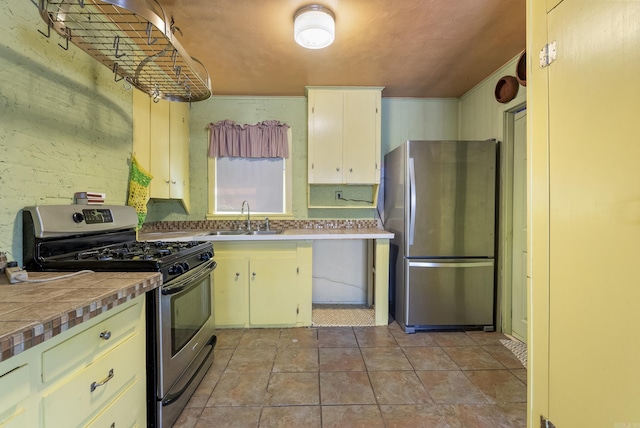 kitchen featuring tile counters, white cabinetry, sink, and appliances with stainless steel finishes