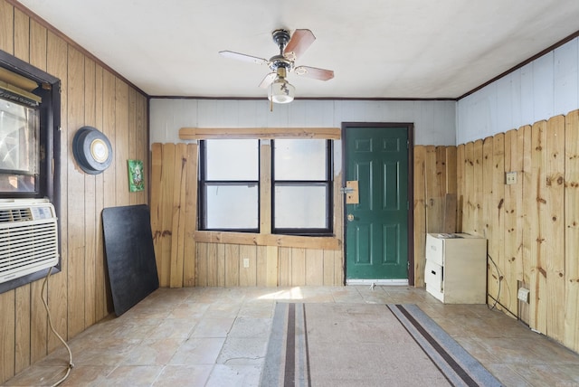 unfurnished room with a wealth of natural light, ceiling fan, and wooden walls