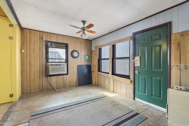 entrance foyer featuring cooling unit, crown molding, ceiling fan, and wooden walls