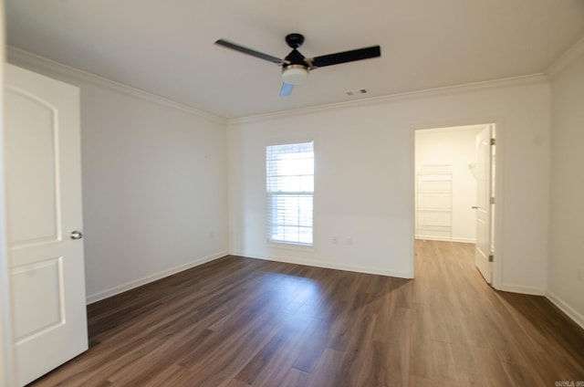 spare room with ceiling fan, crown molding, and dark wood-type flooring