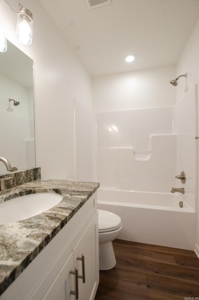 full bathroom with toilet, vanity, bathing tub / shower combination, and hardwood / wood-style floors