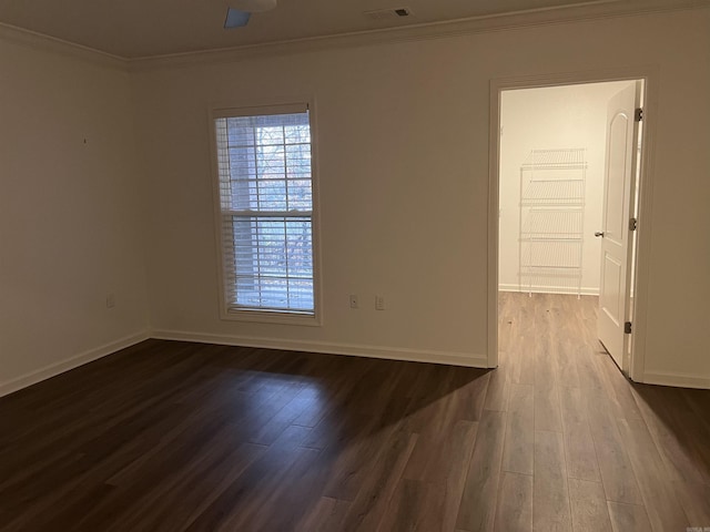 empty room with ornamental molding, a healthy amount of sunlight, and hardwood / wood-style flooring