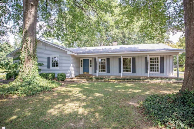 single story home featuring covered porch and a front yard