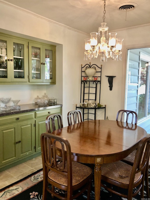 dining room featuring crown molding, light tile patterned flooring, and a chandelier