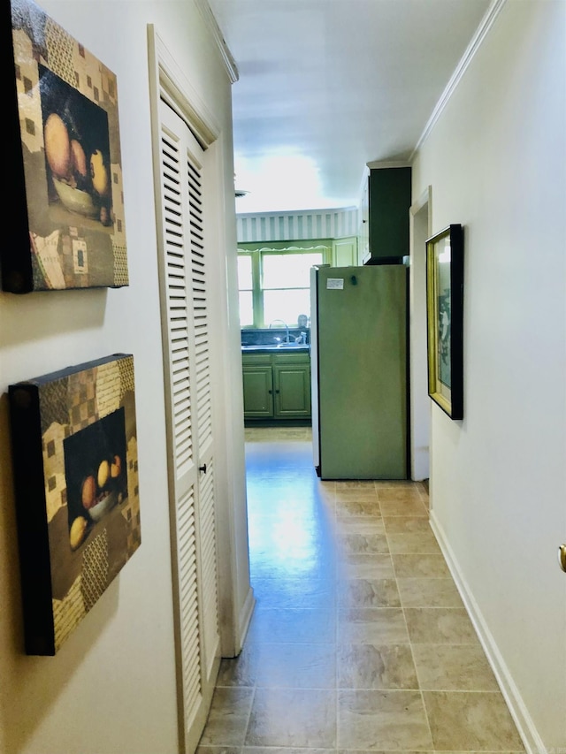 corridor featuring ornamental molding and sink