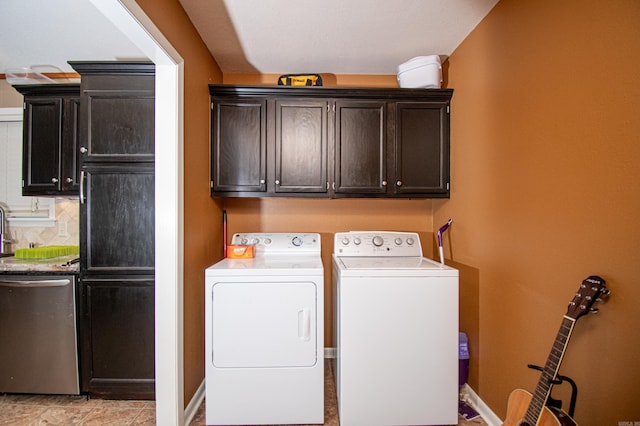 washroom featuring washing machine and clothes dryer and cabinets