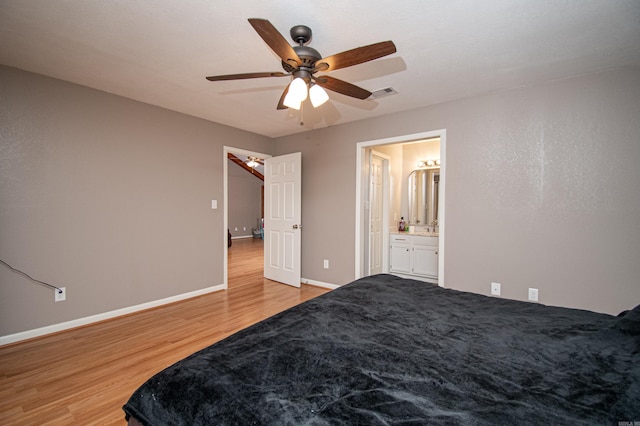 bedroom with ensuite bath, ceiling fan, and light hardwood / wood-style floors