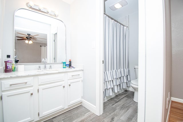 bathroom with hardwood / wood-style flooring, ceiling fan, toilet, and vanity