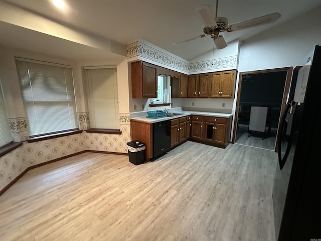 kitchen featuring ceiling fan, sink, black appliances, light hardwood / wood-style floors, and lofted ceiling