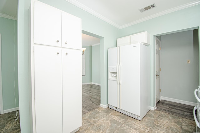 kitchen featuring white refrigerator with ice dispenser, white cabinetry, and ornamental molding