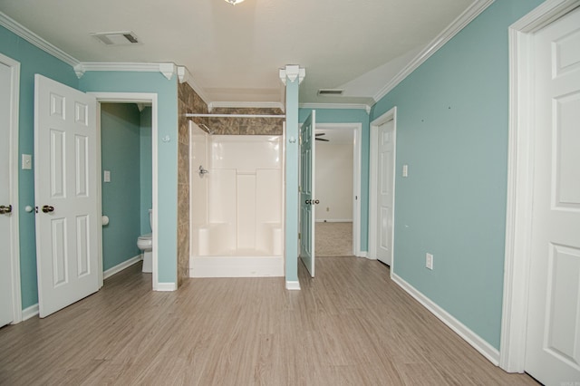 unfurnished bedroom featuring crown molding, light hardwood / wood-style flooring, and ensuite bathroom