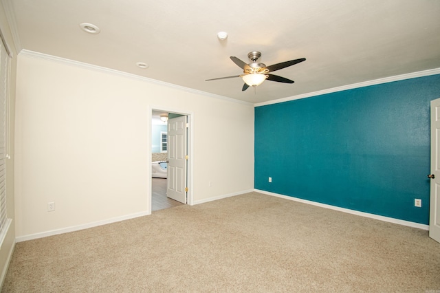 carpeted empty room with ceiling fan and ornamental molding