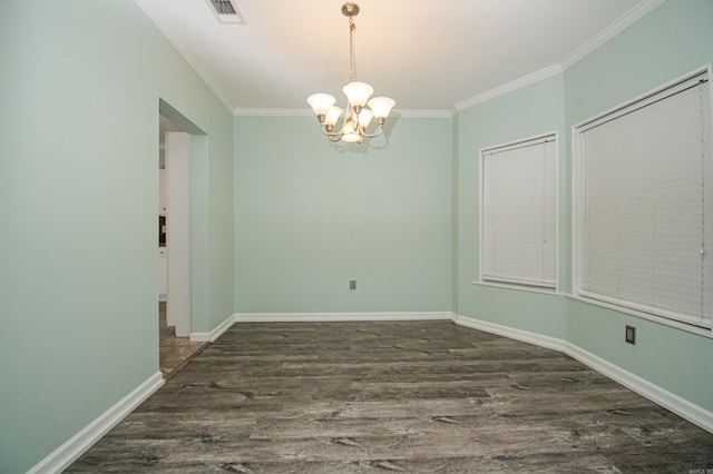 spare room featuring dark hardwood / wood-style flooring, ornamental molding, and a notable chandelier