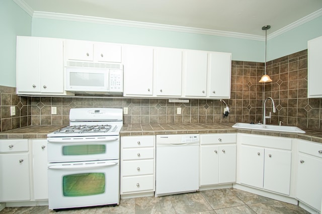 kitchen featuring sink, white cabinets, pendant lighting, and white appliances