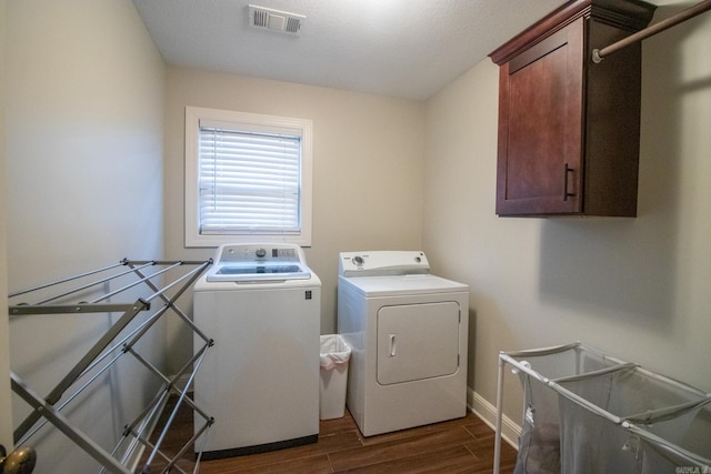 clothes washing area with washer and clothes dryer and cabinets