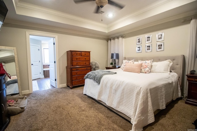 carpeted bedroom featuring ceiling fan, a tray ceiling, ornamental molding, and ensuite bathroom