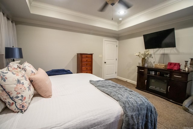 carpeted bedroom with ceiling fan, crown molding, and a raised ceiling