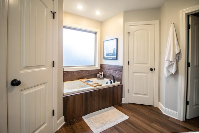 bathroom with a tub and wood-type flooring