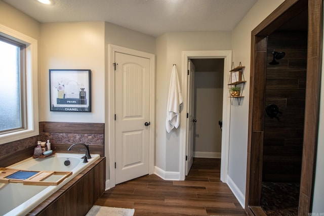 bathroom featuring wood-type flooring and separate shower and tub