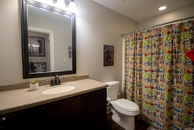 bathroom with toilet, vanity, and a shower with shower curtain