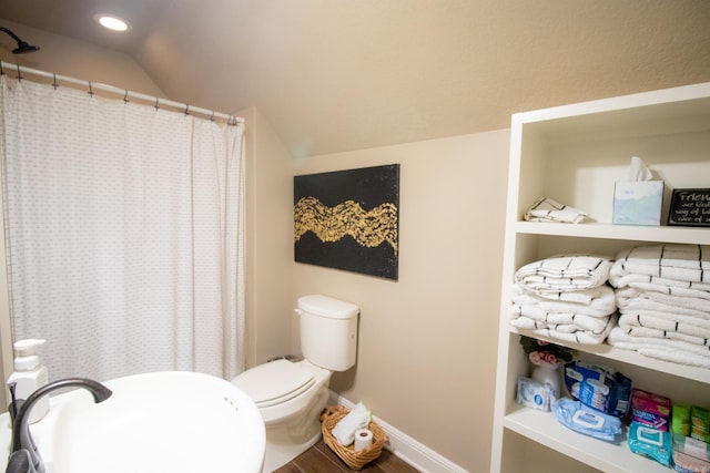 bathroom with lofted ceiling, sink, toilet, and hardwood / wood-style floors