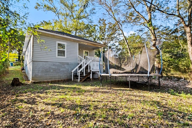 rear view of property with a trampoline